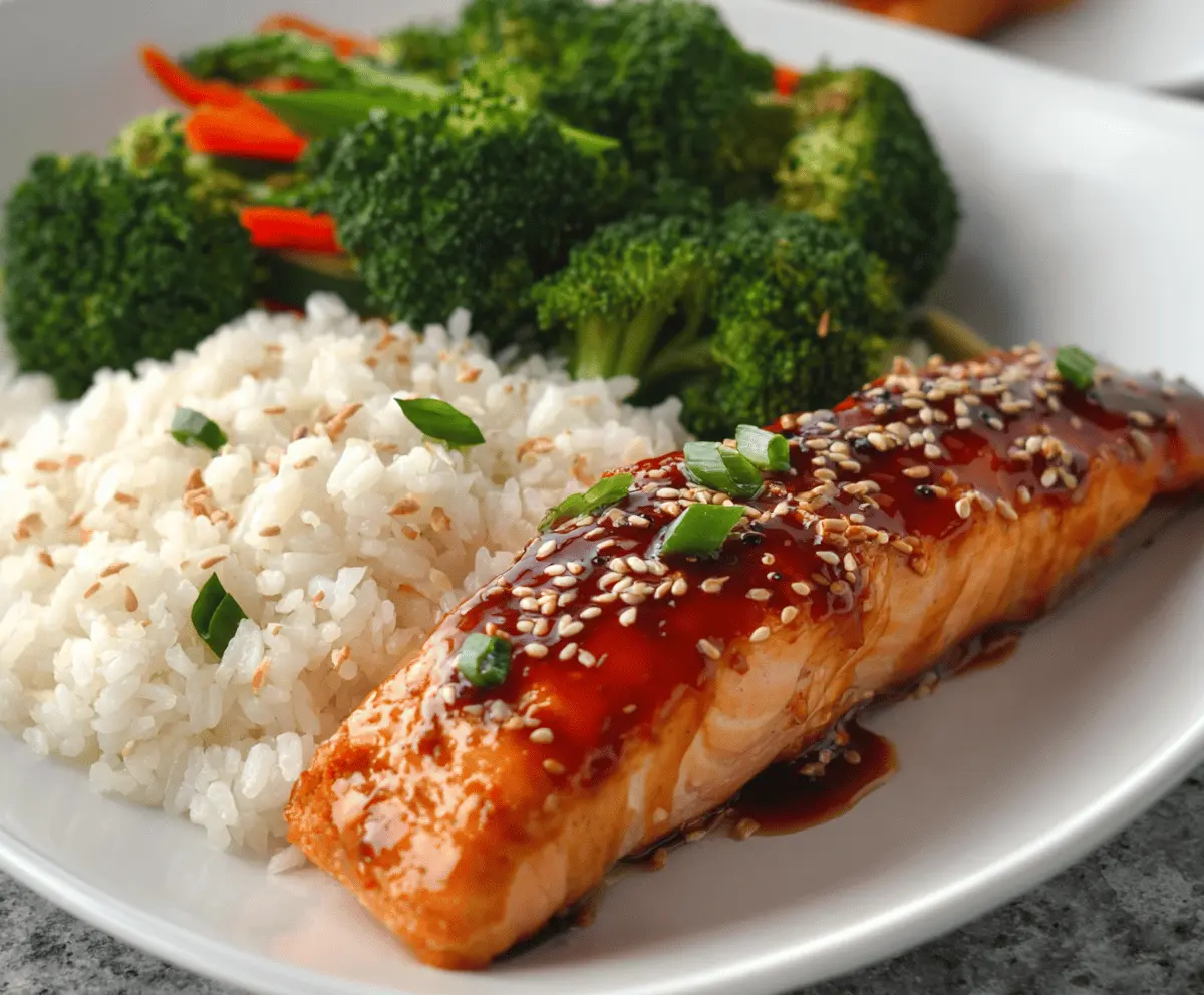 Delicious savory teriyaki salmon fillet garnished with fresh herbs, served on a white plate with vegetables, perfect for a healthy dinner