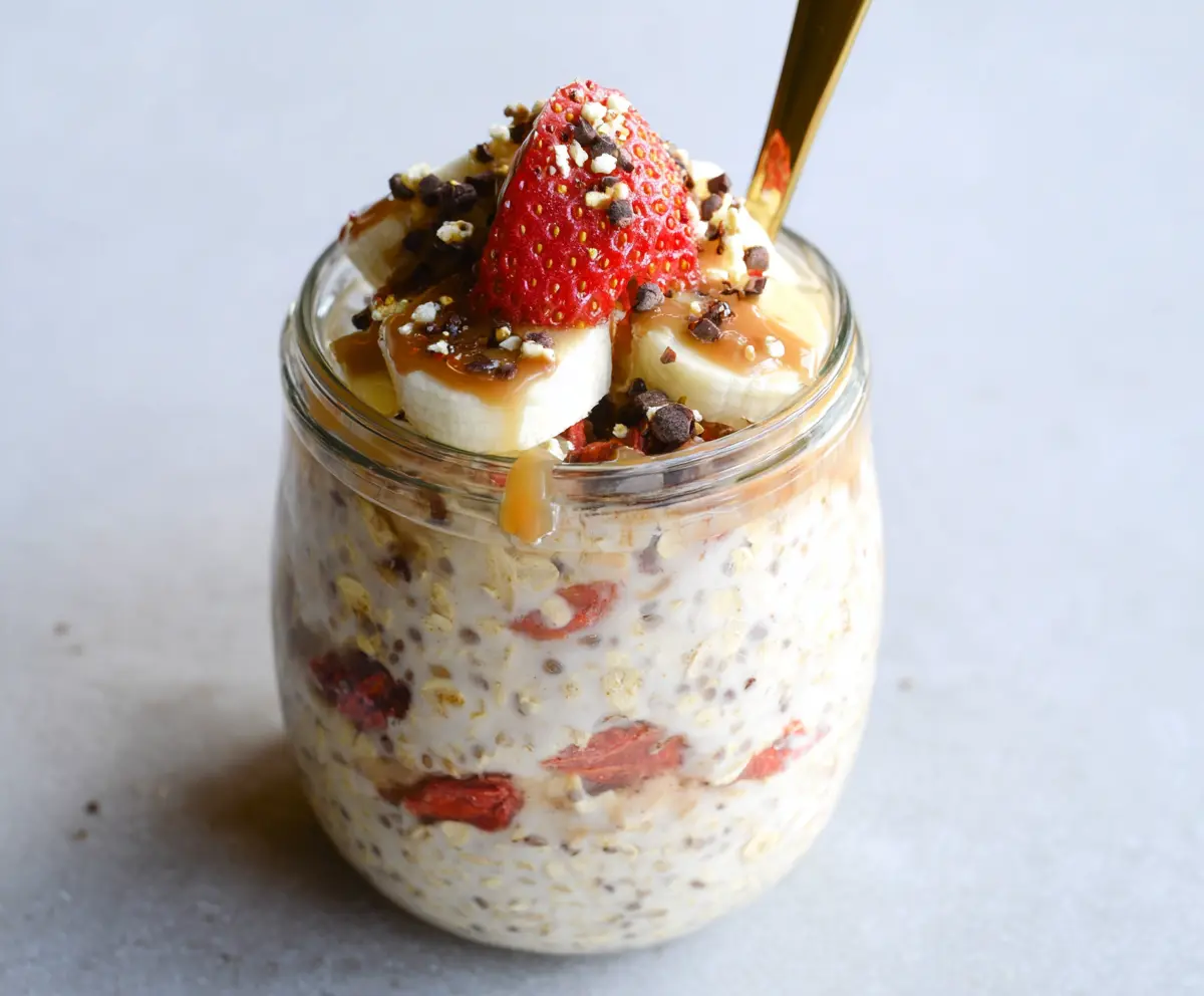 Creamy Banana Split Overnight Oats topped with fresh fruit and whipped cream for a delicious breakfast treat.