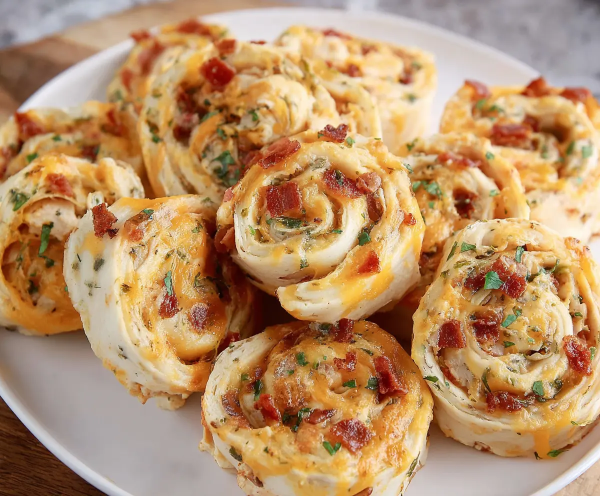 Delicious Crack Chicken Pinwheels filled with creamy cheesy chicken mixture and crispy bacon on a baking sheet.