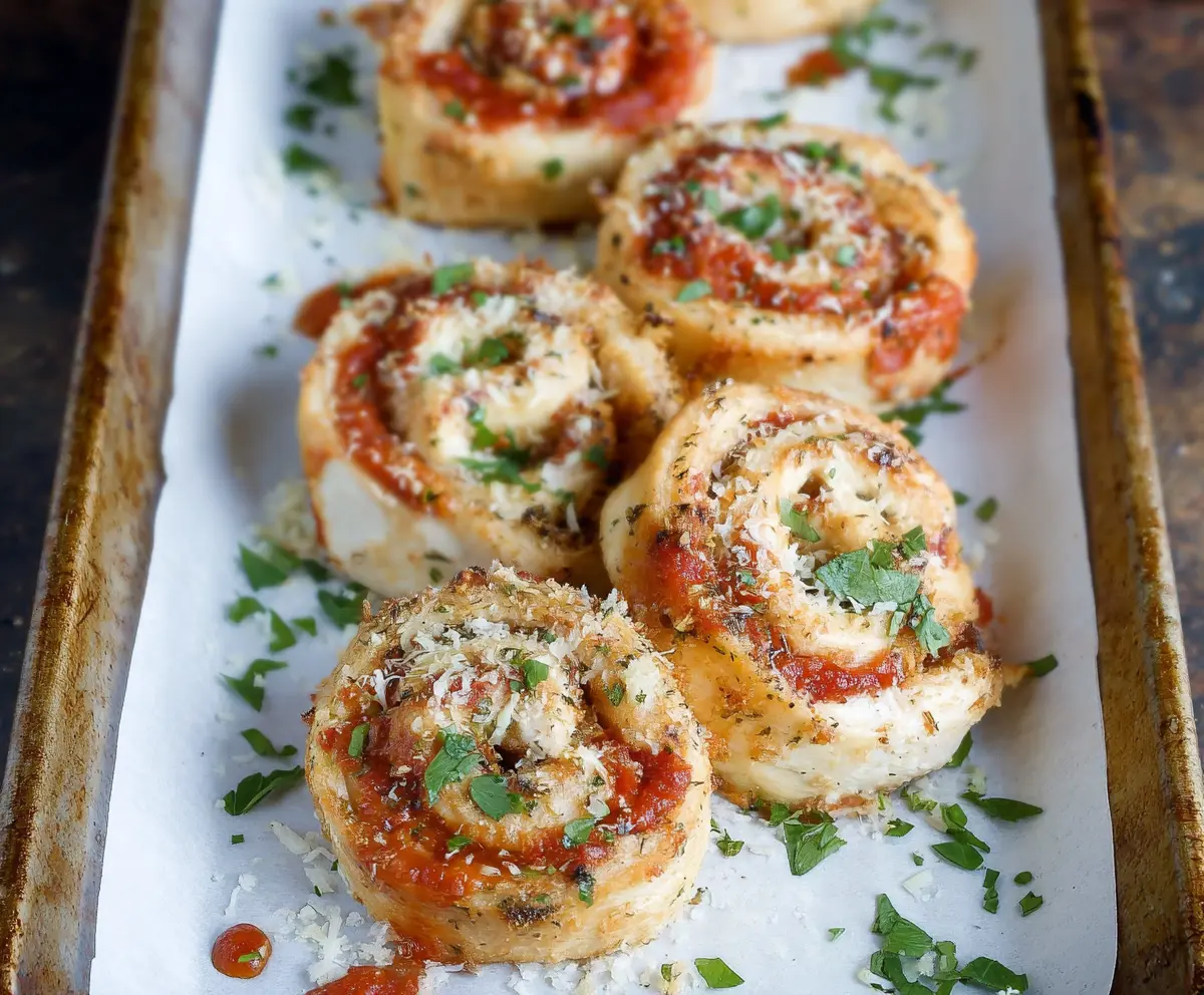 Garlic Parmesan Chicken Pinwheels on a platter, showcasing flaky pastry filled with seasoned chicken and cheese.