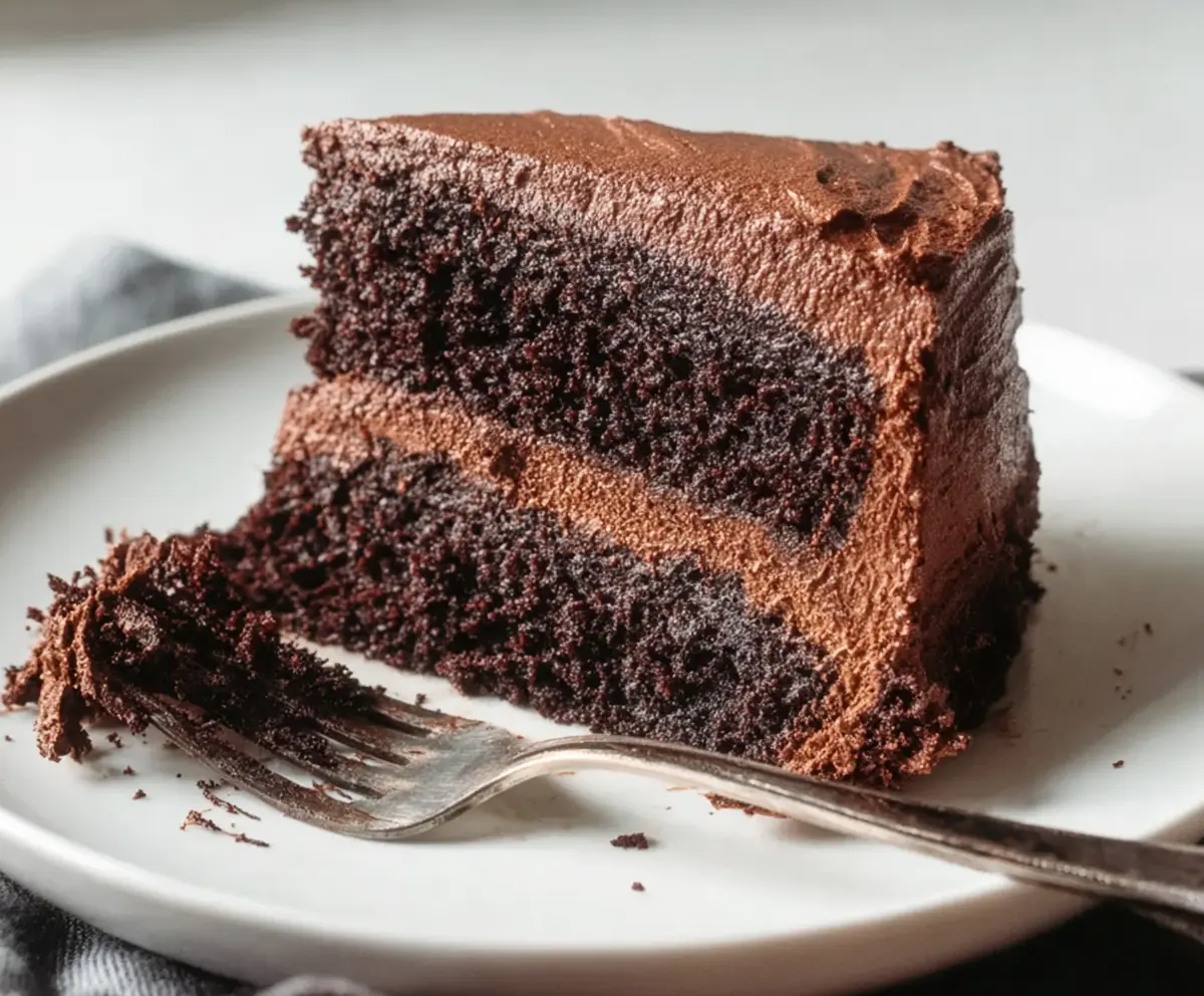 Delicious sourdough discard chocolate cake topped with chocolate shavings and fresh berries.