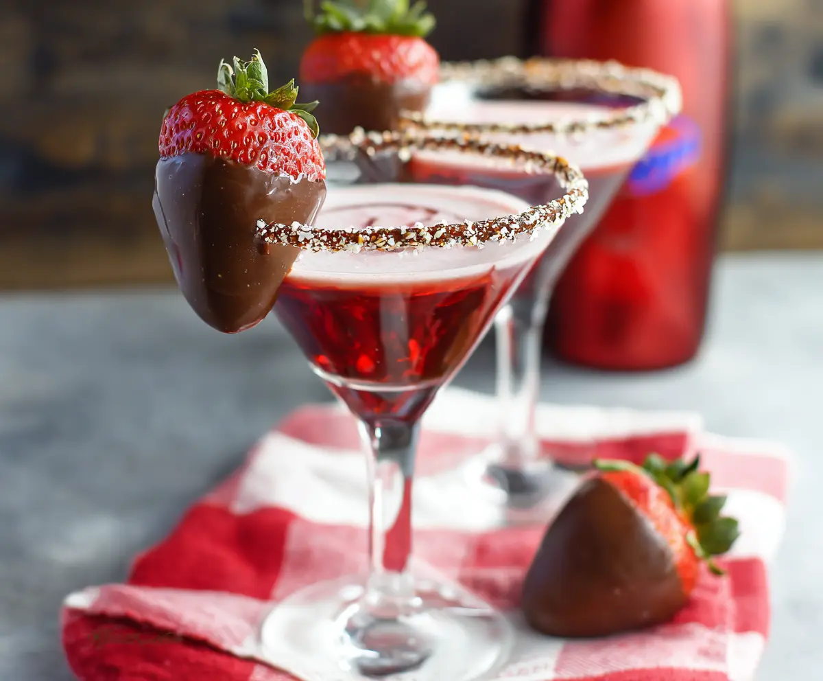Elegant Chocolate Covered Strawberry Martini in a cocktail glass with fresh strawberries and chocolate drizzle.
