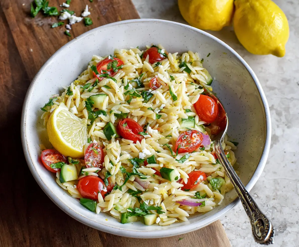 Fresh Lemon Orzo Pasta Salad with herbs and cherry tomatoes in a white bowl