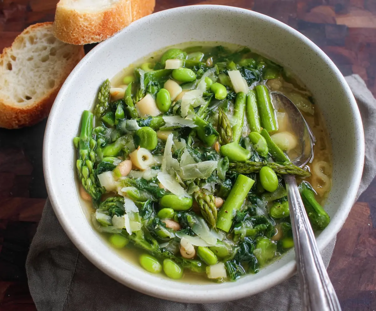 Fresh Spring Green Minestrone Soup with vibrant vegetables in a white bowl, perfect for a healthy meal.